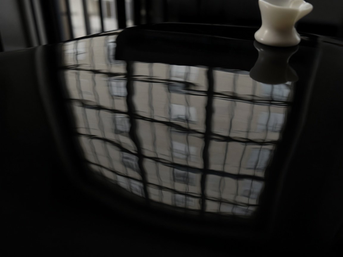 Polished black acrylic reflecting a window